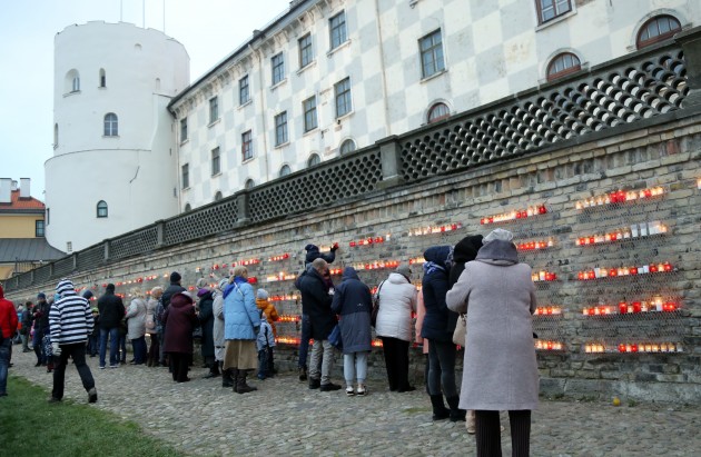 Lāčplēša diena, cilvēki noliek svecītes pie Rīgas pils mūra - 1