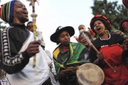 South Africans sing to honour the life of former President Nelson Mandela outside his home in Houghton, Johannesburg
