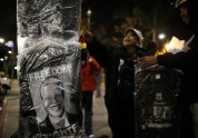 A woman buys a souvenir T-shirt at a candlelight vigil in memoriam of Nelson Mandela s death, in Los Angeles, California
