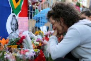 A woman cries after placing flowers in front of a picture of late South African former president Nelson Mandela during an inter-faith service