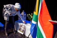 A woman places a photo during a remembrance ceremony for late former South African President Nelson Mandela at the Bijlmer Park theater in Amsterdam