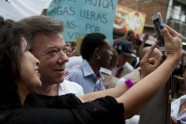 Colombian President Juan Manuel Santos poses for a selfie with a supporter during a campaign rally
