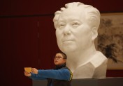 A man takes a self-portrait in front of a statue of China’s late Chairman Mao Zedong