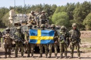 Swedish soldiers pose for a photo as troops from Poland, USA, France and Sweden take part in the DEFENDER-Europe 22 military exercise, in Nowogrod, Poland on May 19, 2022