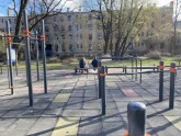 Jauna ģimene ar bērnu ratos dzer no rīta bērnu laukumiņā Rīgā